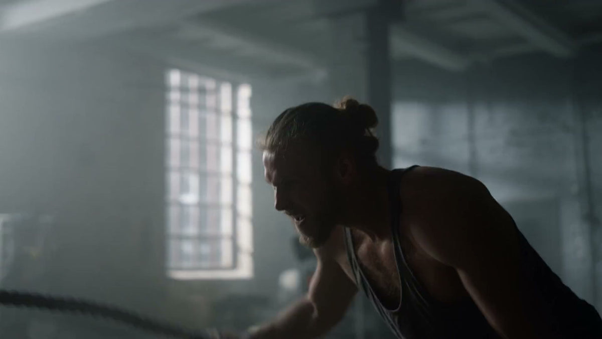 Athlete training with battle ropes in a gym