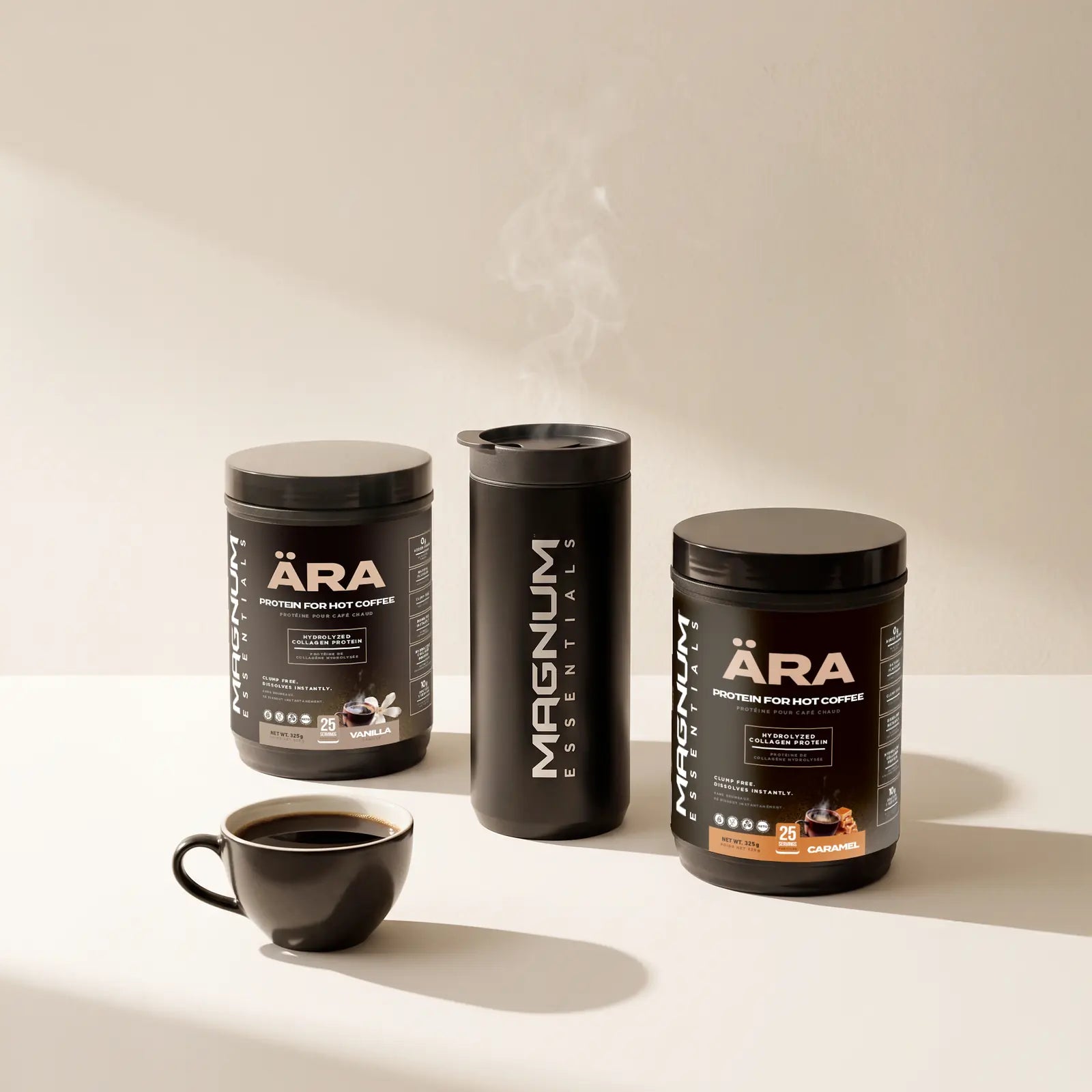 ÄRA Vanilla and Caramel tubs standing beside a matte black Magnum Essentials tumbler and a small cup of black coffee